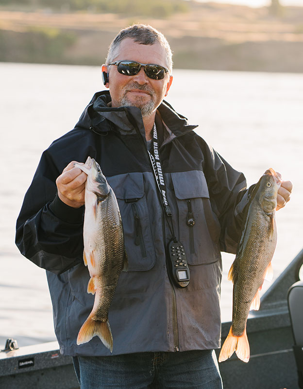 Pikeminnow Fisherman with two Northern Pikeminnow fish.